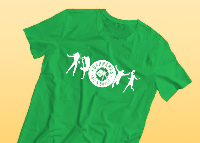 A green t-shirt with Barnabus safe and sound printed on it, including their logo which is a white silhouette four different people dancing 
