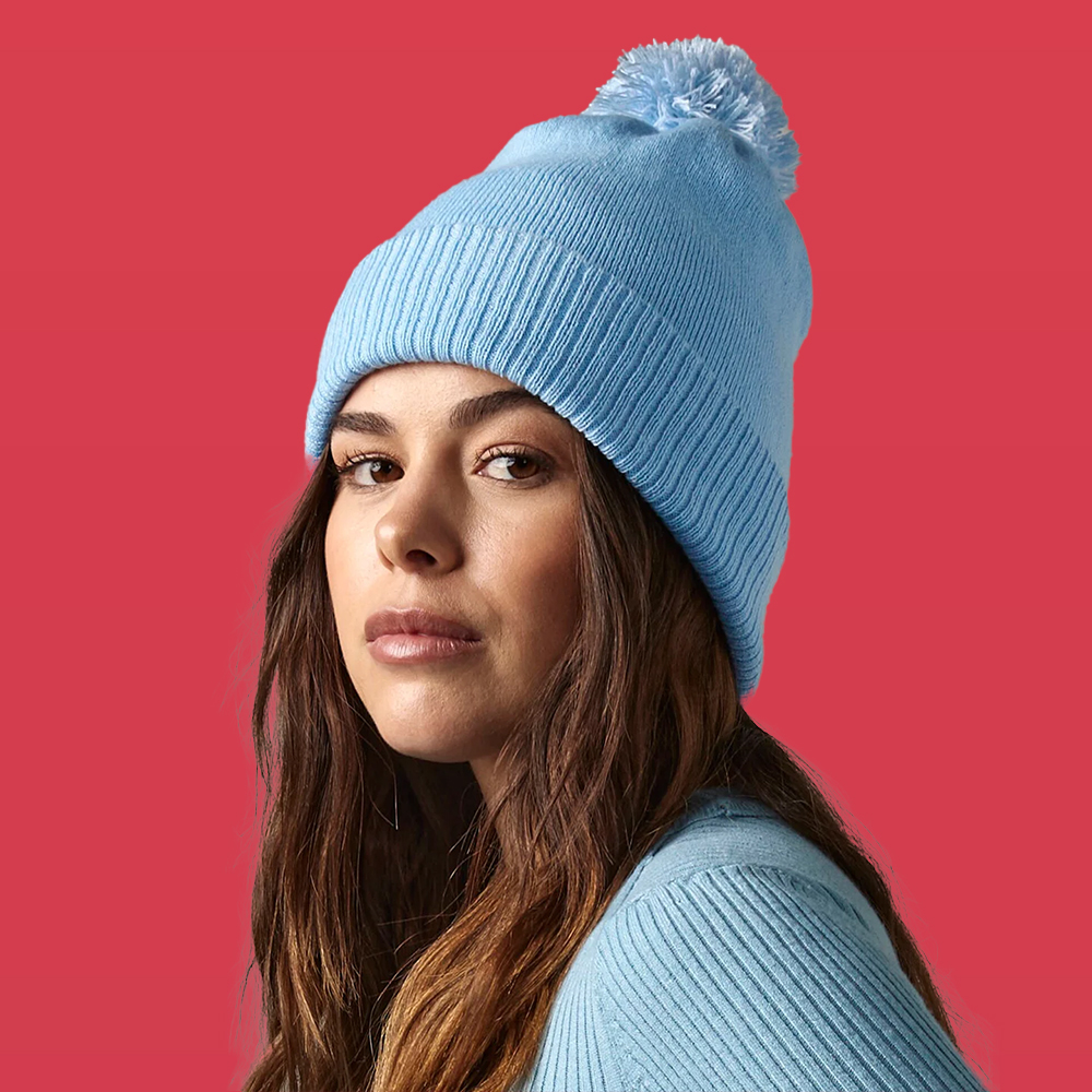 Woman wearing a custom embroidered blue beanie 